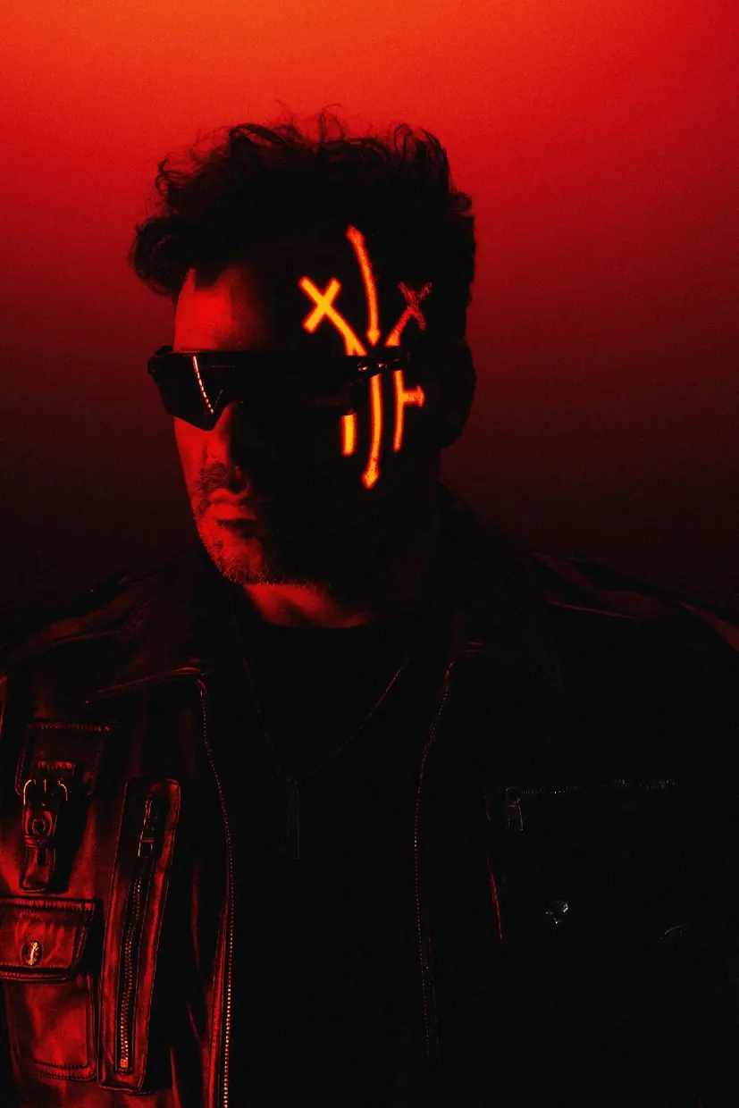 Portrait in red light with the MRAK mark projected on the face